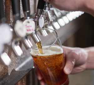 bartender pouring craft beer from tap